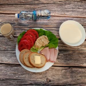 Zdjęcie przedstawia Dietę o kontrolowanej zawartości kwasów tłuszczowych: Zacierka na mleku Chleb mieszany pszenno-żytni Masło extra Pomidor Kawa zbożowa z mlekiem Szynka krucha z pieca wieprzowa,parzona Woda mineralna Sałata zielona Hummus